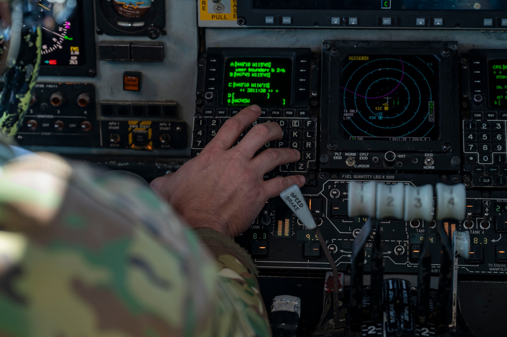 A pilot types information into an airplane computer system.