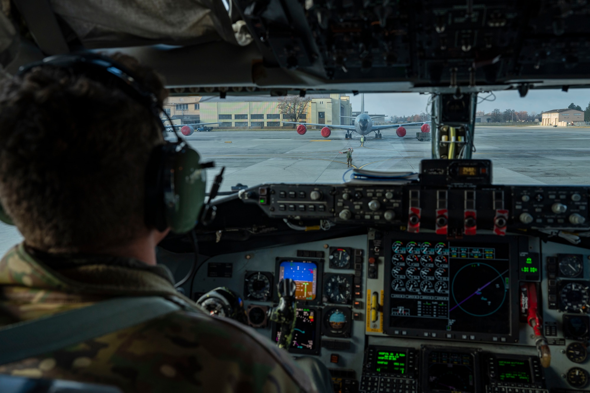 An Airman marshals a plane into place.