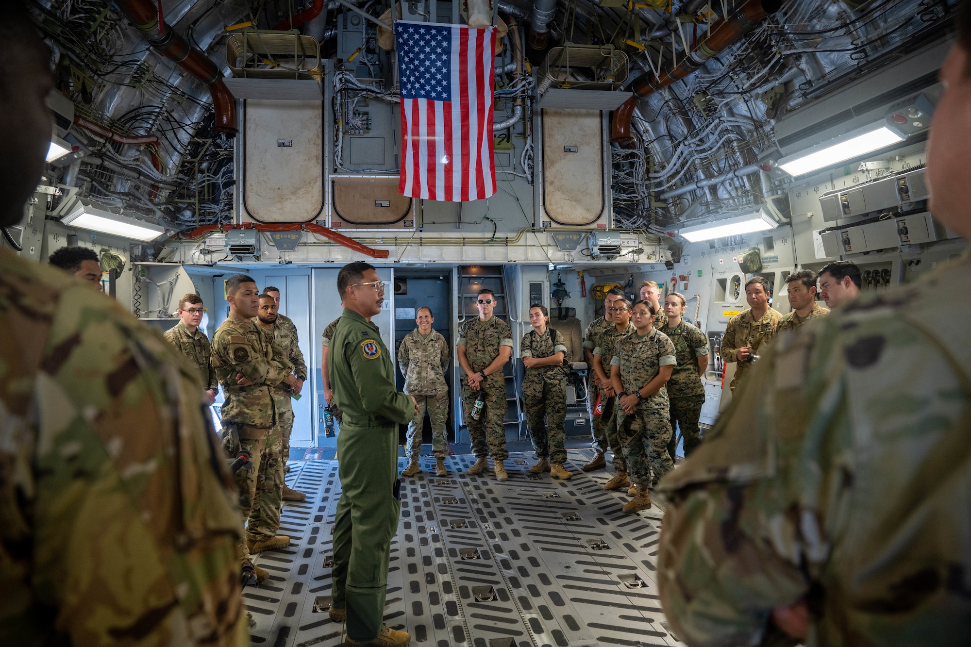An Airman assigned to the 18th Aeromedical Evacuation Squadron briefs medical service members from around the island during an aeromedical evacuation showcase at Joint Base Pearl Harbor-Hickam, Hawaii, Nov. 17, 2023. Hickam Airmen hosted the AE showcase, inviting medical service members from all branches across the island to learn about the AE mission and how the C-17 Globemaster III supports it. (U.S. Air Force photo by Senior Airman Makensie Cooper)