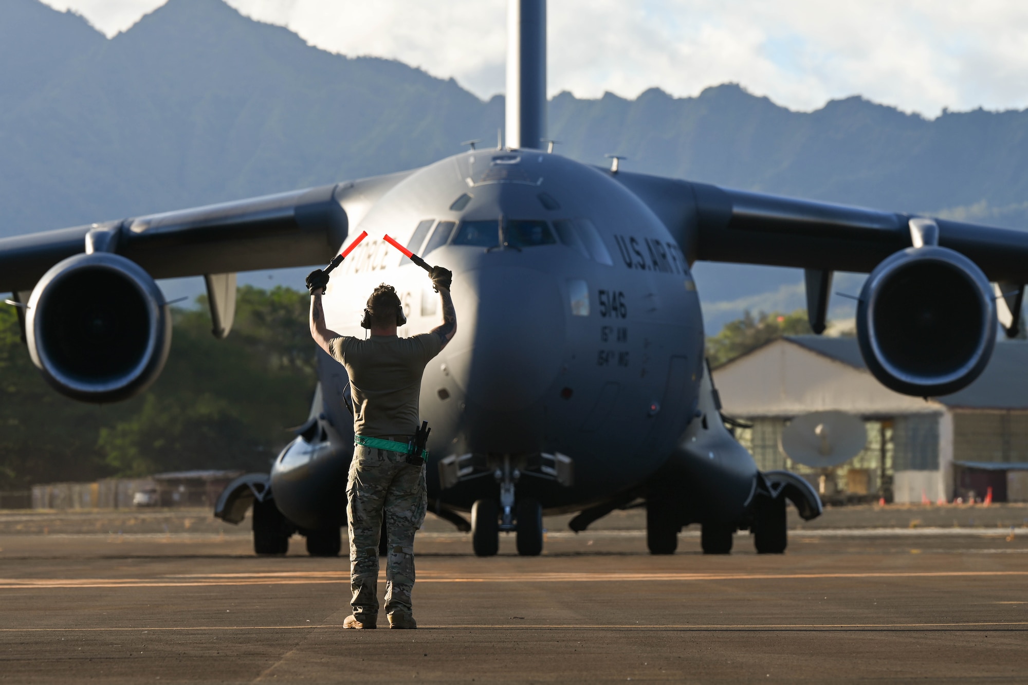 Staff Sgt. Robert Patterson, 621st Contingency Response Squadron aircraft maintainer, marshals in a C-17 Globemaster III during the Joint Pacific Multinational Readiness Capability exercise at Wheeler Army Airfield, Hawaii, Nov. 3, 2023.