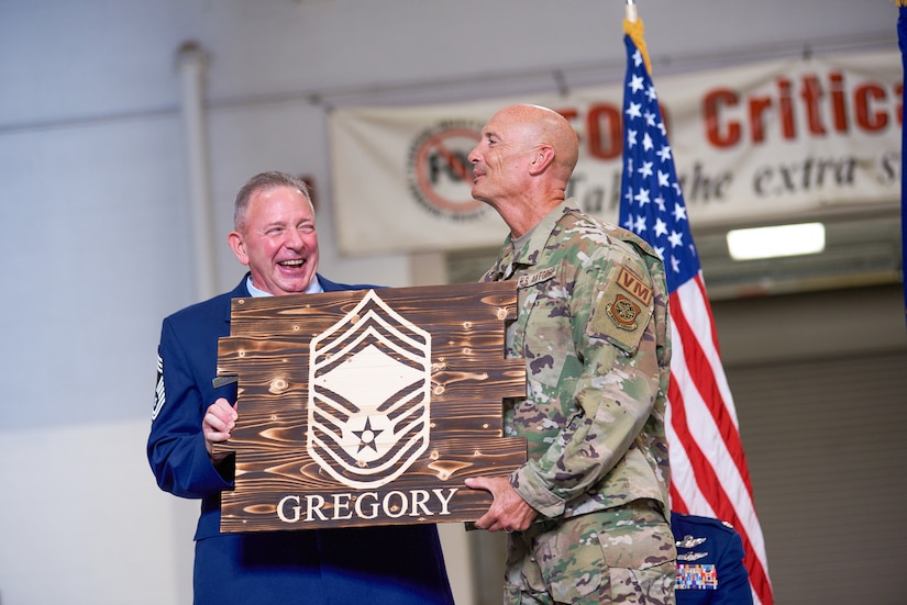 Chief Master Sgt. Danny Gregory, left, senior enlisted leader of the Kentucky Air National Guard’s 165th Airlift Squadron Flight Engineer Section, receives a plaque from Chief Master Sgt. Jamie Fox, chief enlisted leader of the 123rd Logistics Readiness Squadron, at Gregory’s retirement ceremony at the Kentucky Air National Guard Base in Louisville, Ky., Sept. 9, 2023. Gregory retired from the 123rd Airlift Wing after more than 40 years of military service. (U.S. Air National Guard photo by Phil Speck)