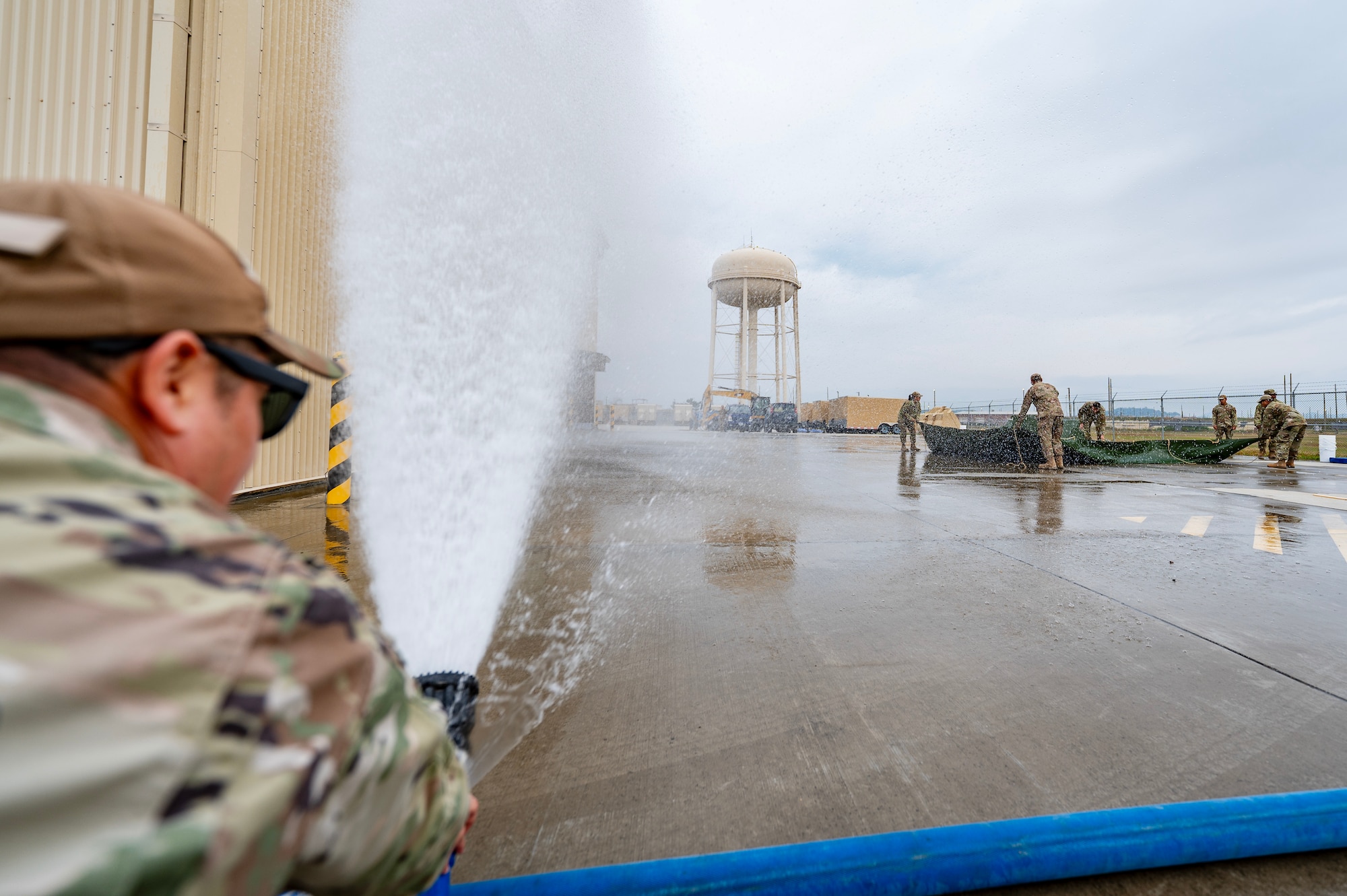 Airman sprays water to simulate a storm during a Prime Base Engineer Emergency Force or “Prime BEEF” training at Kunsan Air Base.