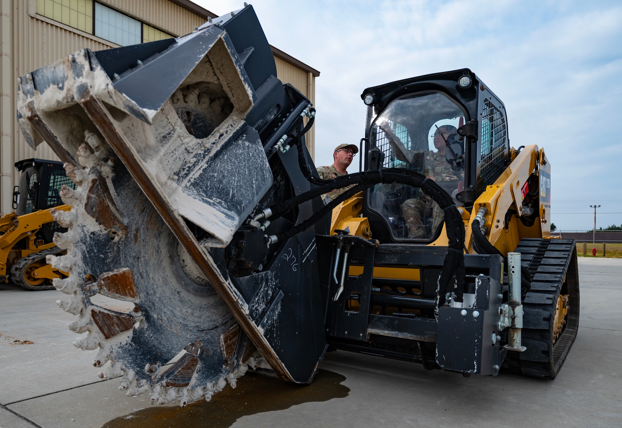 Airman instructs another Airman on procedures to operate a compact track loader during a Prime Base Engineer Emergency Force or “Prime BEEF” training at Kunsan Air Base,