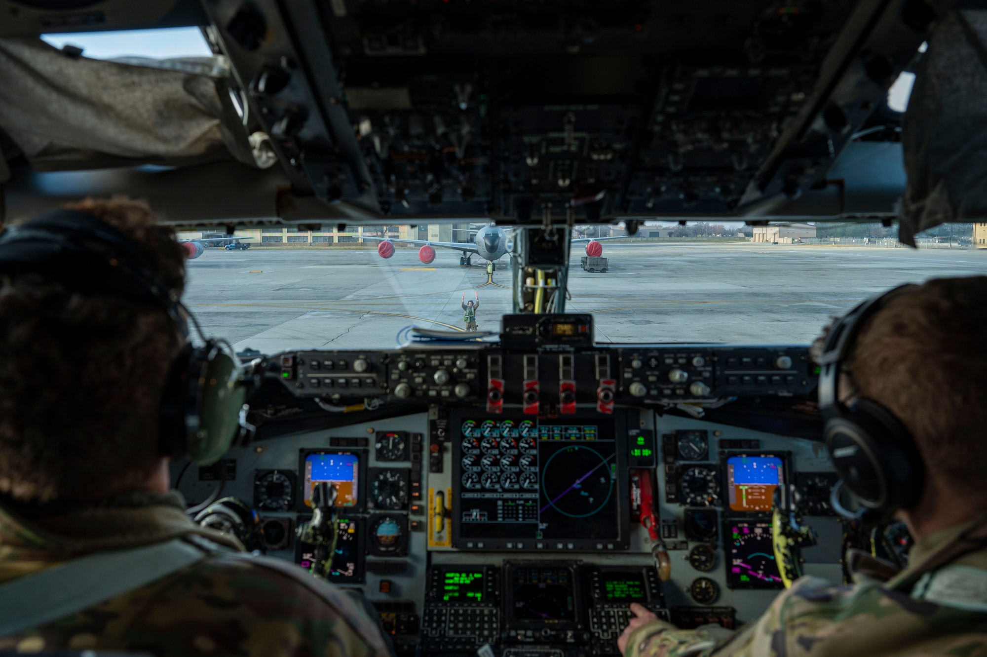 An Airman marshals a plane into place.