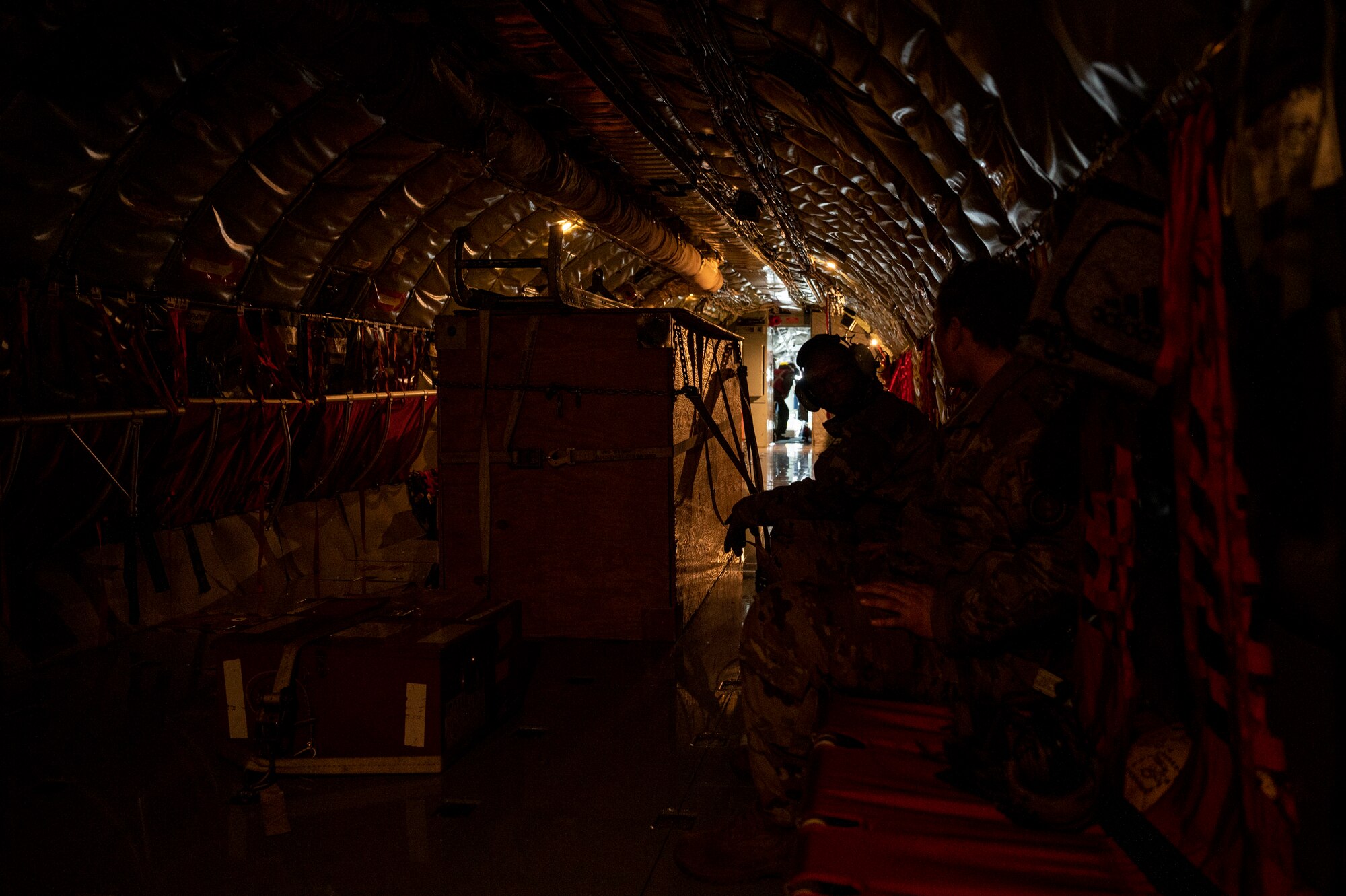 Airmen look in the cockpit of an airplane.