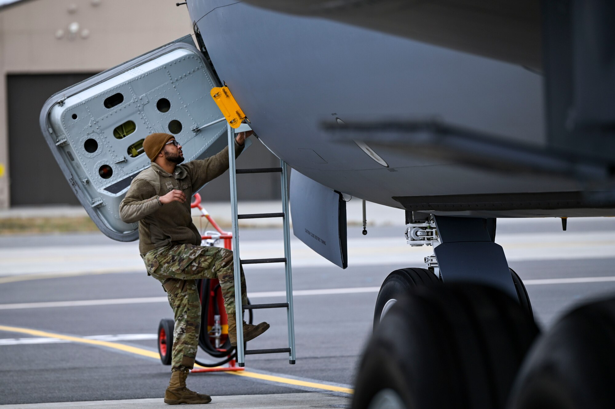 An Airman climbs the ladder of an aircraft.