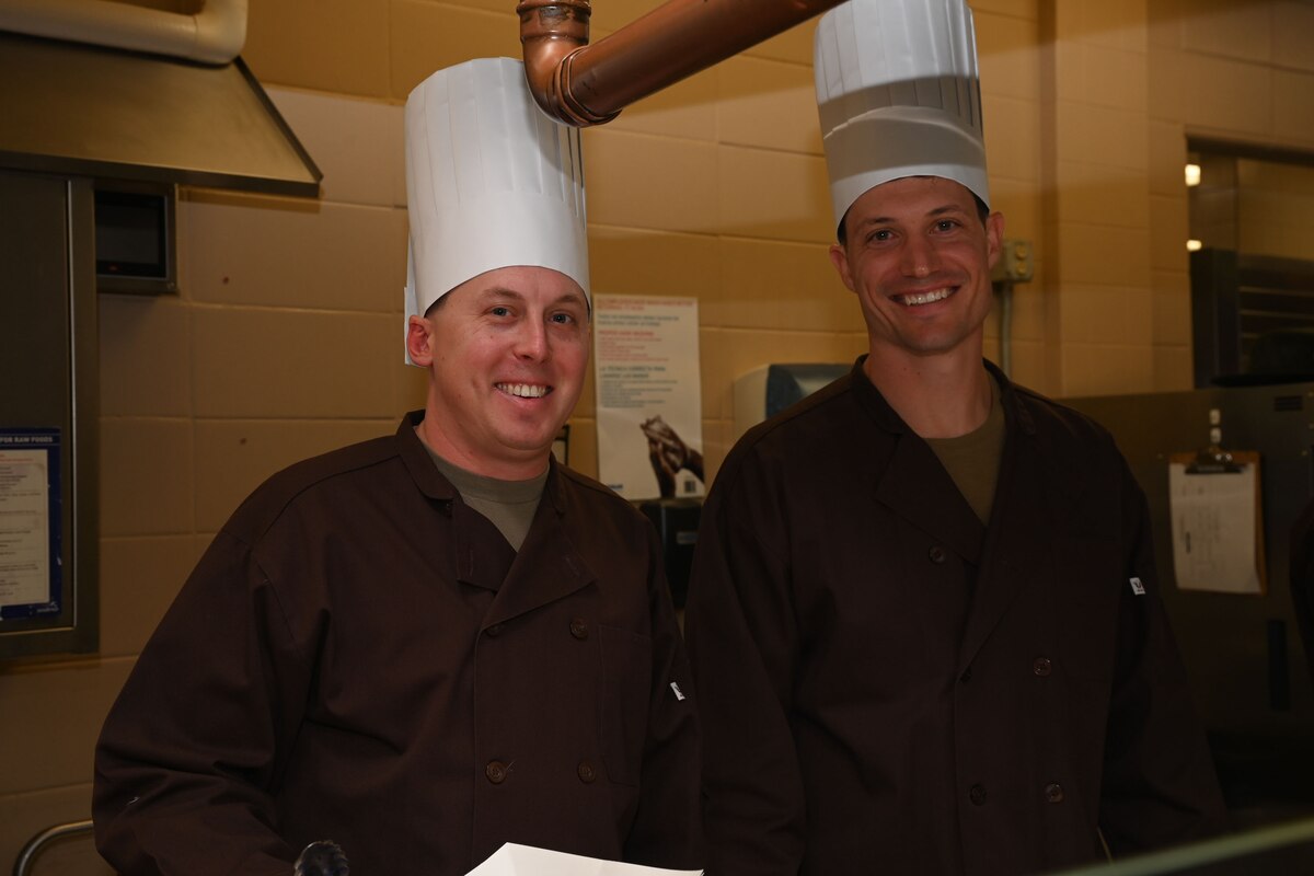 U.S. Army Maj. Jacob Stallings, 344th Military Intelligence Battalion executive officer, left, and Staff. Sgt Peter Martin, 344th MI Battalion platoon advisor, right, volunteer during a Thanksgiving lunch at the Western Winds Dining Facility, Goodfellow Air Force Base, Texas, Nov. 23, 2023. Leaders from all over the base came together to show the students their appreciation for their service. (U.S. Air Force photo by Airman 1st Class Evelyn J. D’Errico)