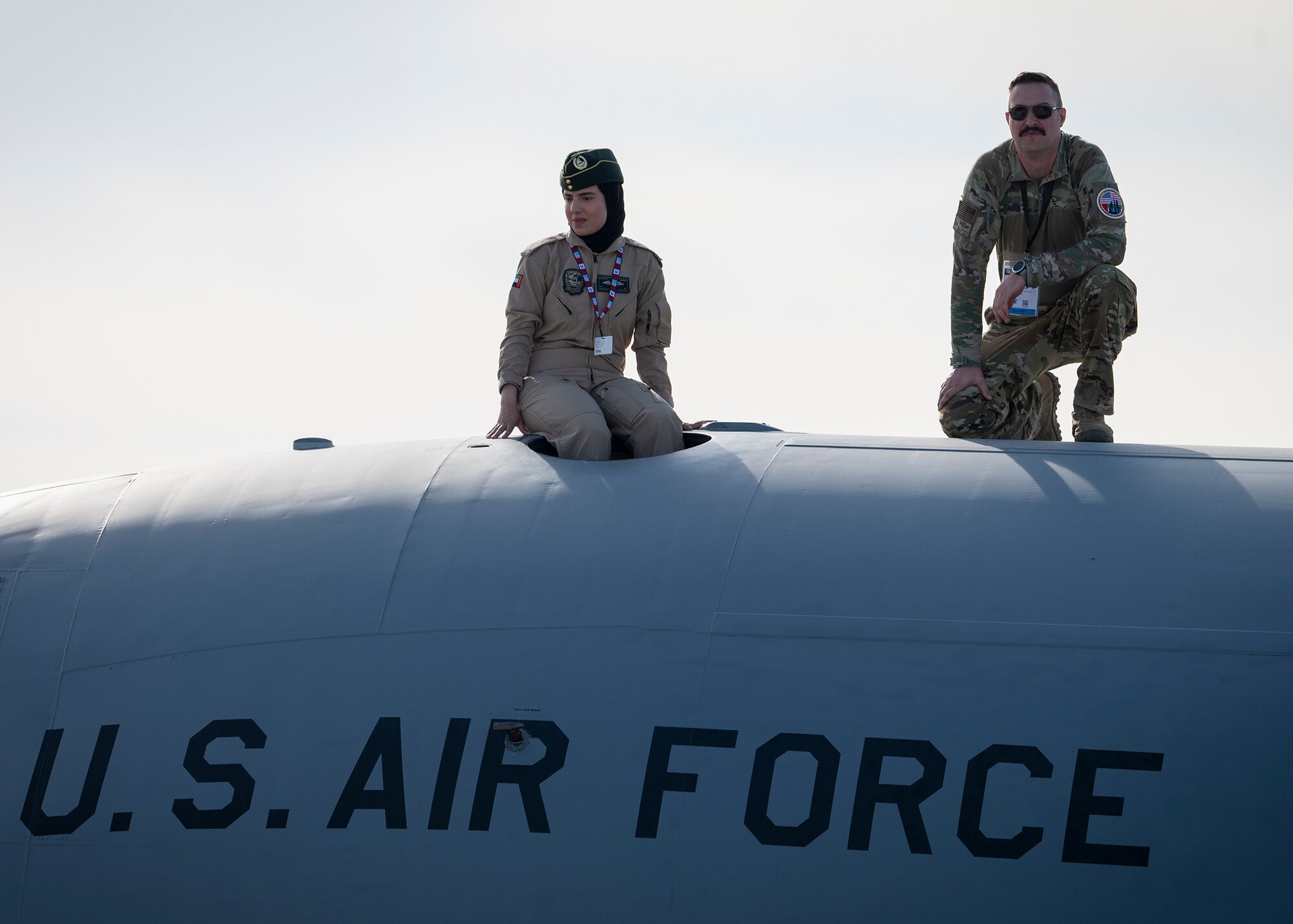 US and UAE service member sit on top of aircraft.