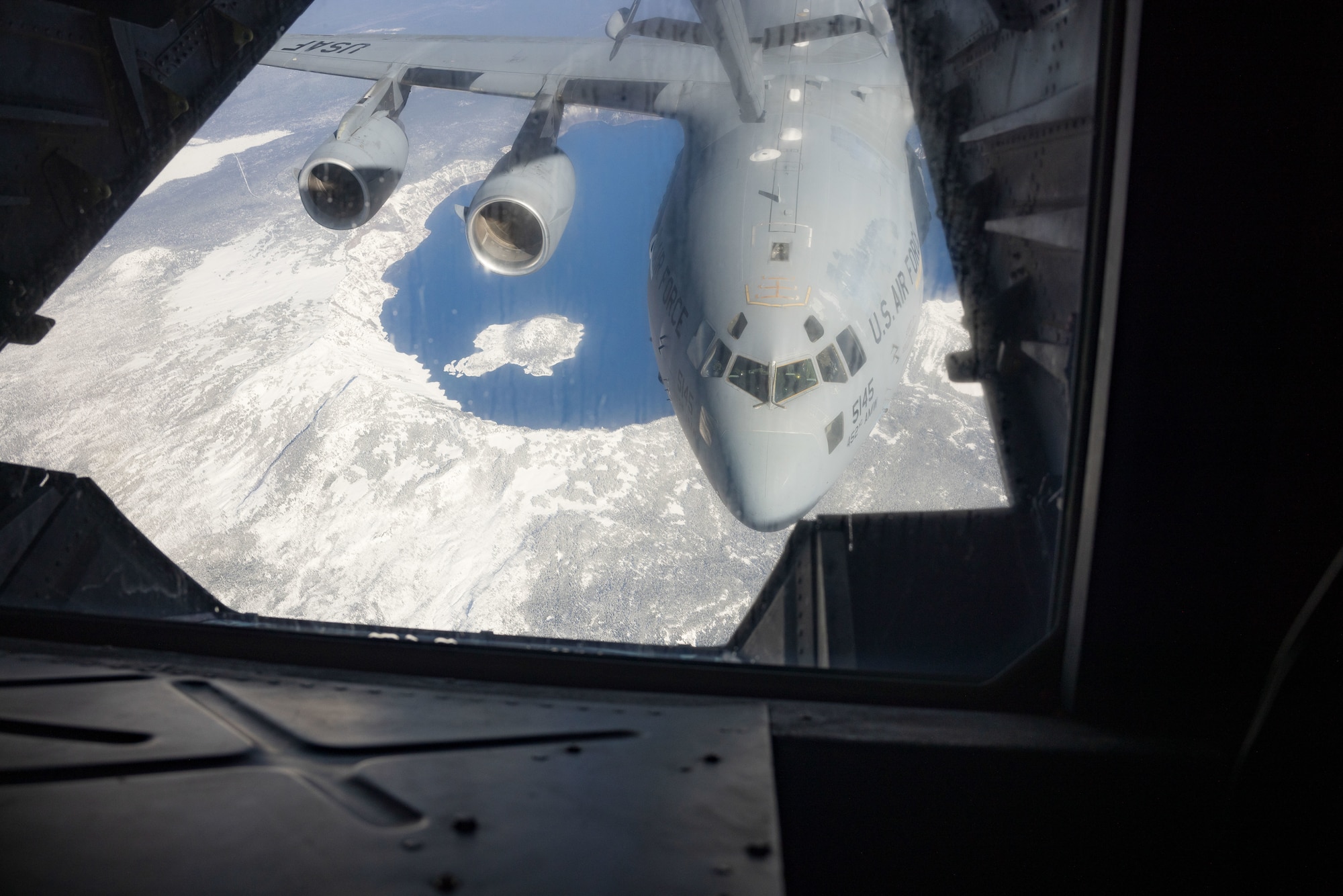 A KC-10 from Travis Air Force Base, Calif. simulates air refueling while flying over Crater Lake, Calif.