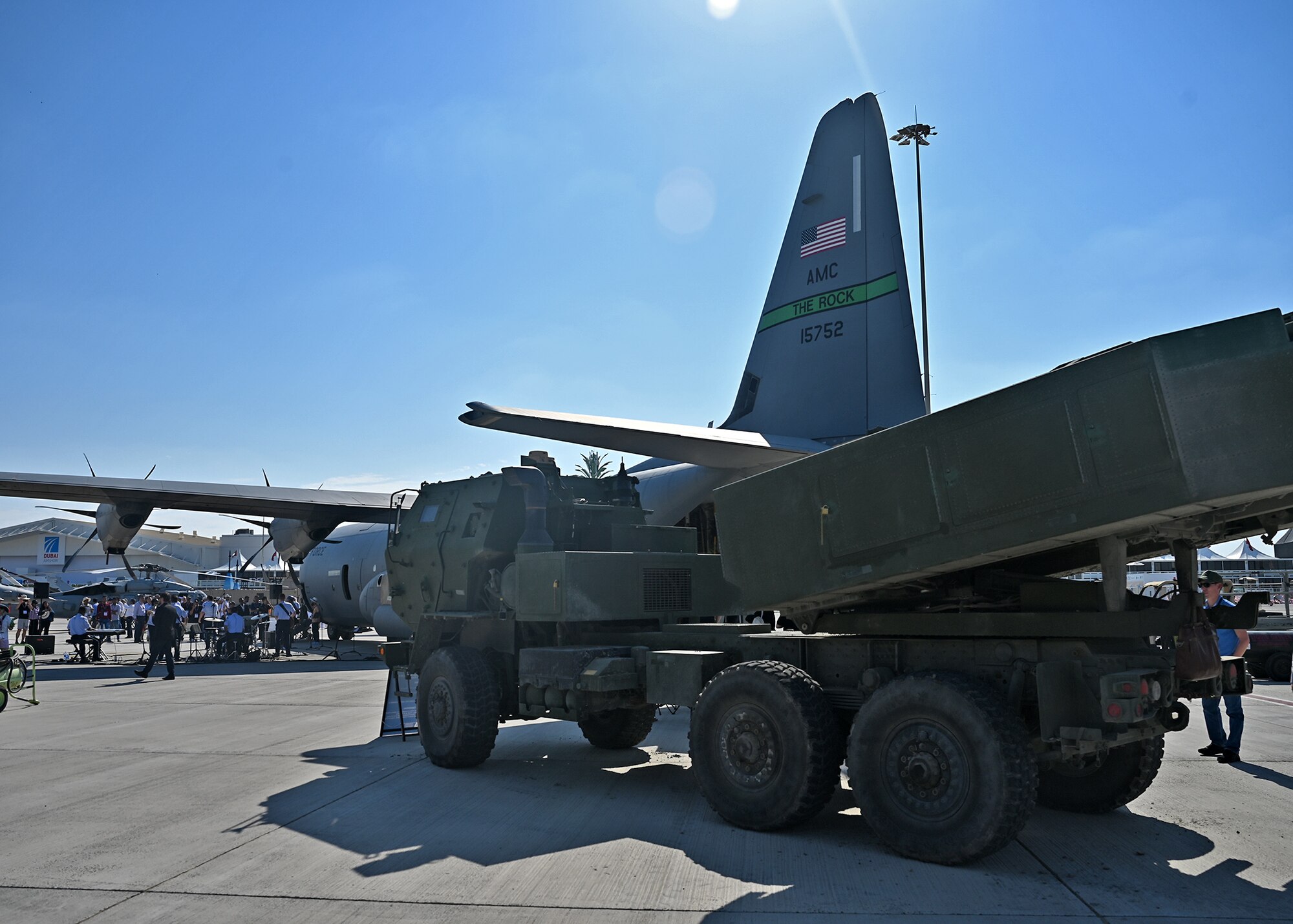 Aircraft and vehicles sit on flight line.
