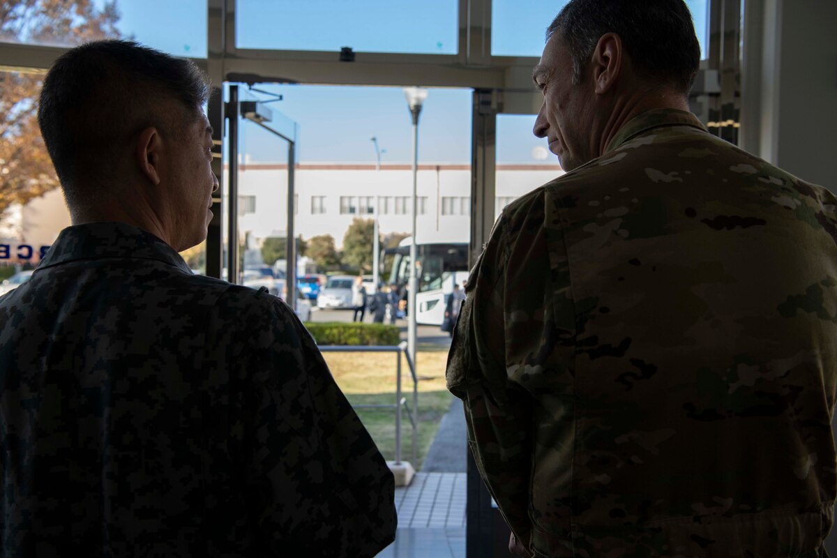 Two military men look at each other.
