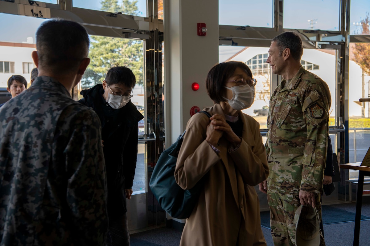 Two military men greet a group of Japanese nationals.