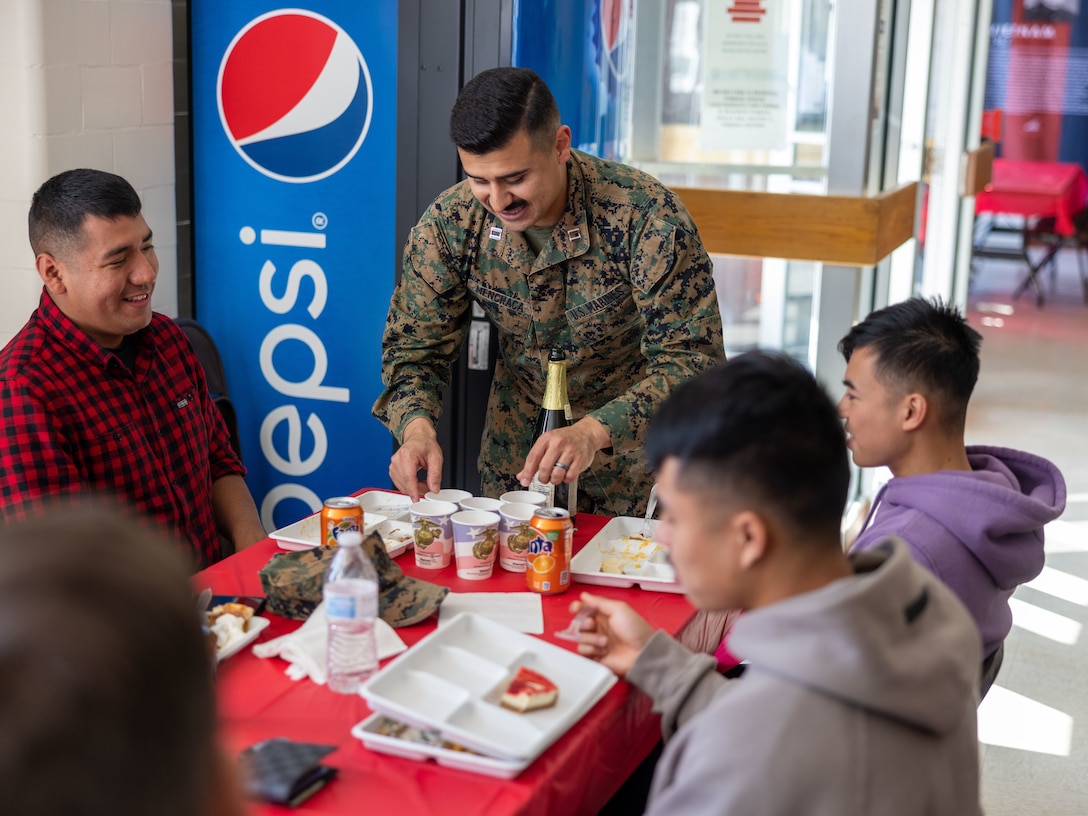 U.S. Marine Corps Captain Moses Menchaca, Headquarters Company commanding officer, Security Battalion, hands out drinks to Marines as they participate in the Security Battalion Turkey Feast on Marine Corps Base Quantico, Virginia, Nov. 18, 2022. Security Battalion’s annual Turkey Feast is a way for the Staff Non-Commissioned Officers and Officers of Security Battalion to give back and serve junior Marines as a part of the Thanksgiving holiday. (U.S. Marine Corps photo by Captain Michael Curtis)