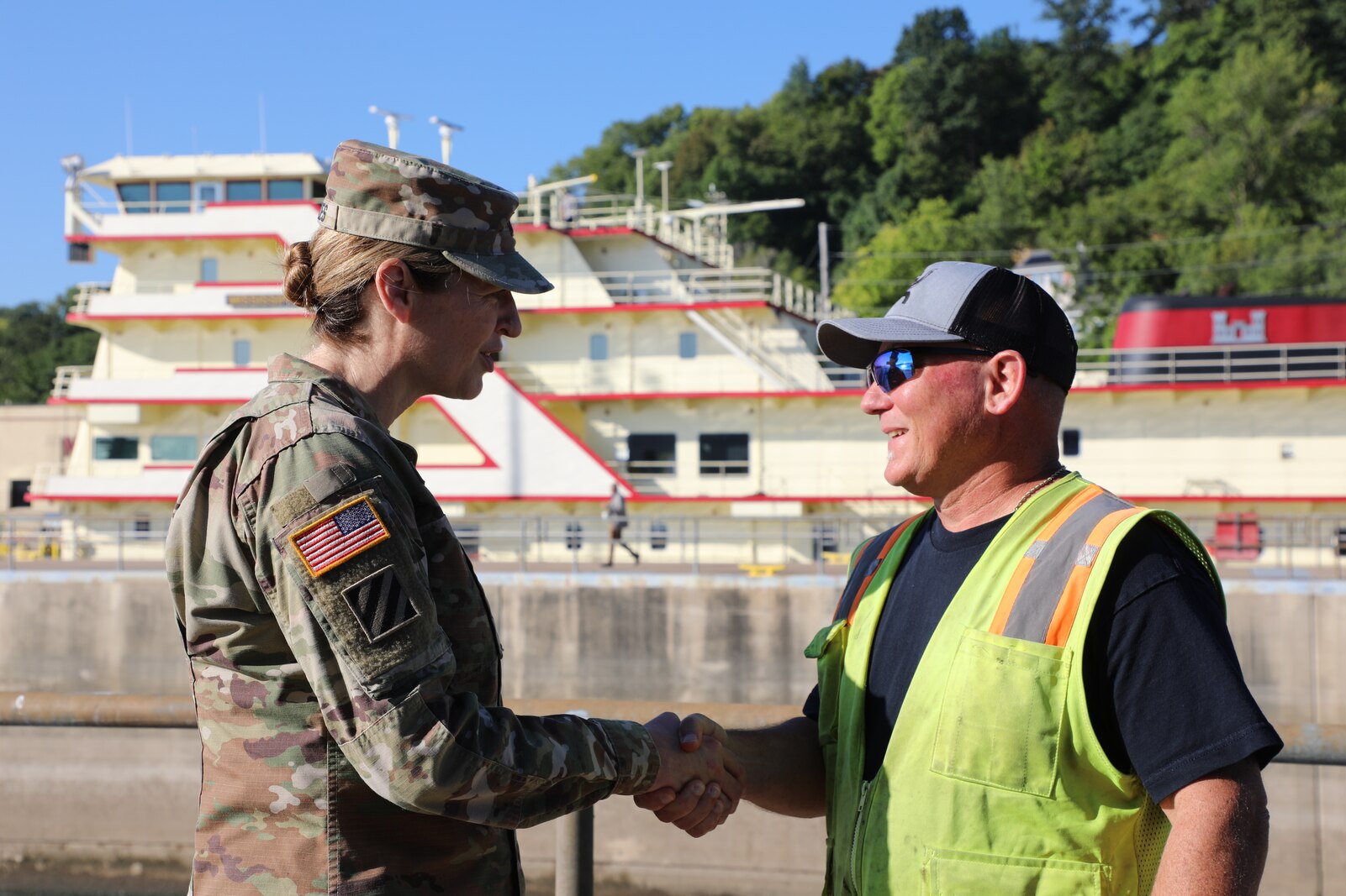 Army officer and worker shake hands