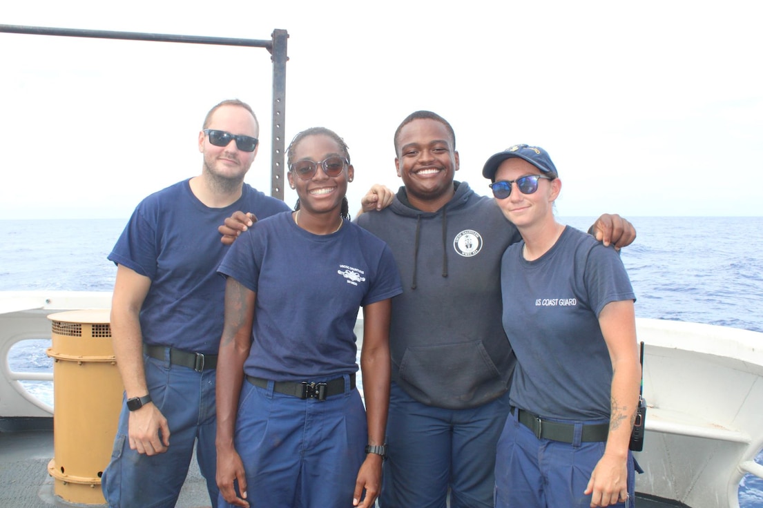 U.S. Coast Guard Seaman Nicholas Krikstan, far left, Seaman Ariayanna Val, Seaman Nur Ibn Al-Islam, and Petty Officer 1st Class Kalie Jones, far right, pose for a group photo aboard the U.S. Coast Guard Cutter Dauntless (WMEC 624), Aug. 10, 2023, in the Windward Passage.