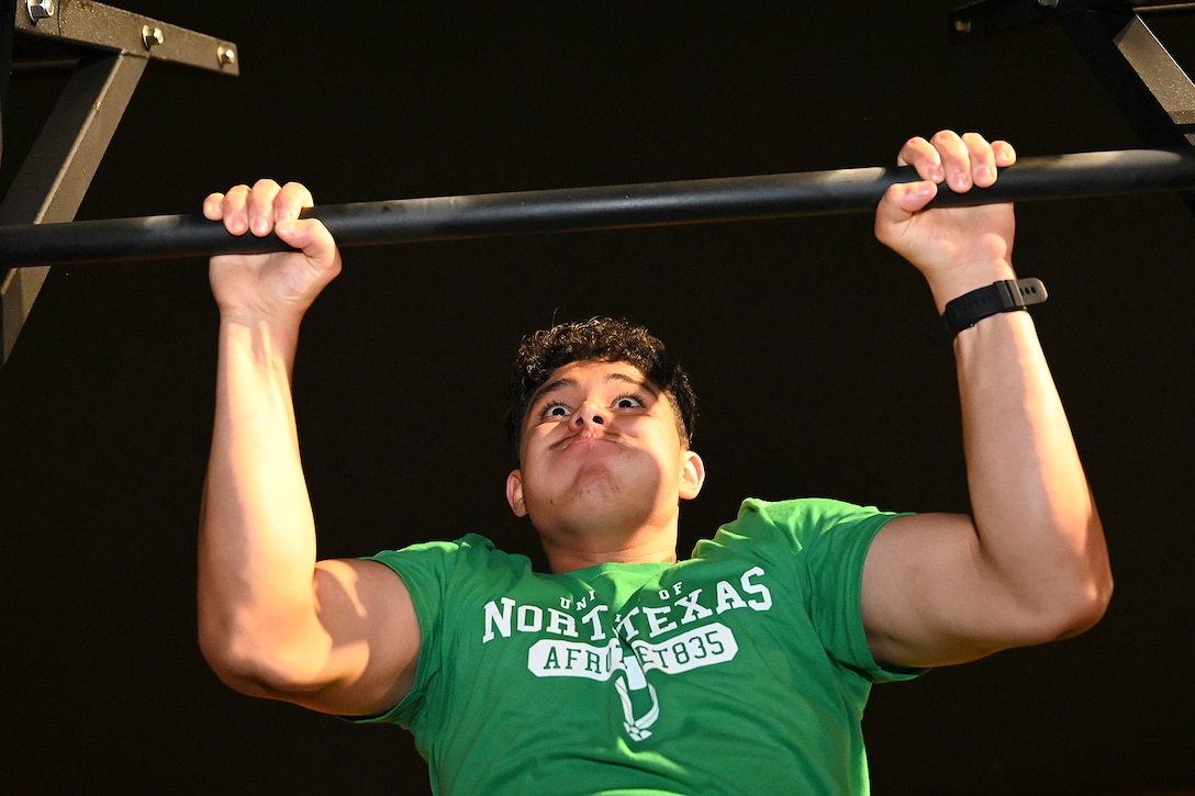 A cadet strains while pulling up on a bar.