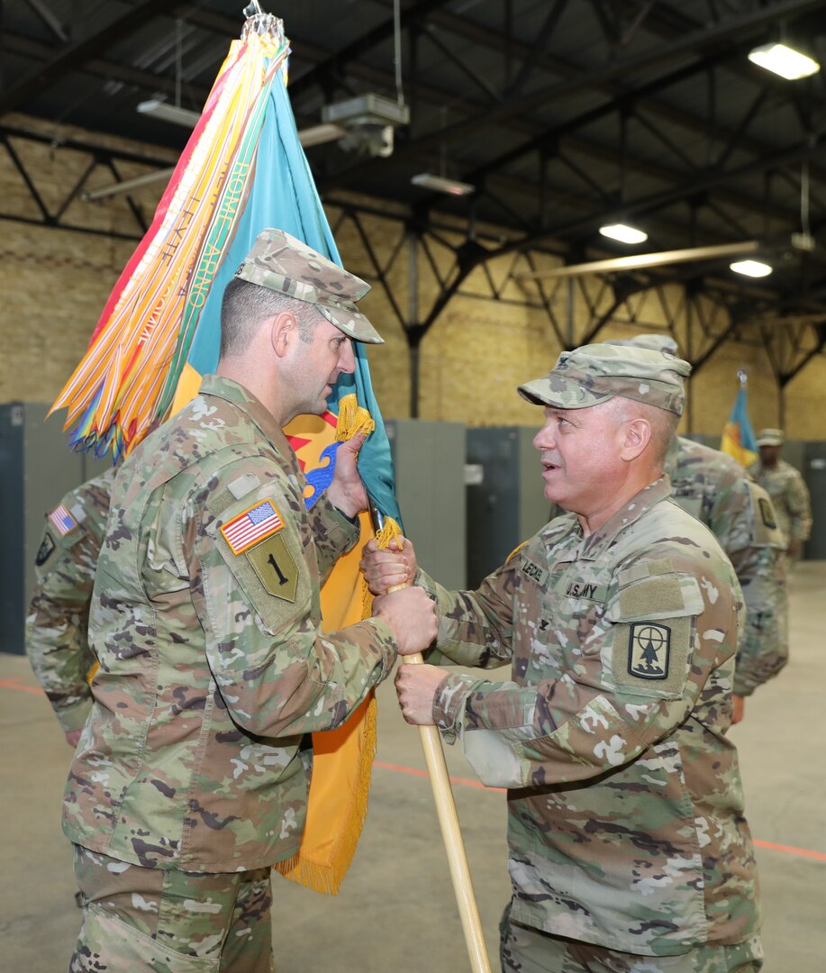 In his last act as commander, Col. Eric Leckel passes the colors of the 157th Maneuver Enhancement Brigade to Brig. Gen. Matthew Strub, Wisconsin’s deputy adjutant general for Army, during a formal change of command ceremony Nov. 4 at the Richards Street Armory, Milwaukee. The passing of the colors is symbolic of the responsibility of the unit passing from one commander to the next. Col. Paul Gapinski assumed command of the brigade. Wisconsin National Guard photo by Sgt. 1st Class Katie Theusch