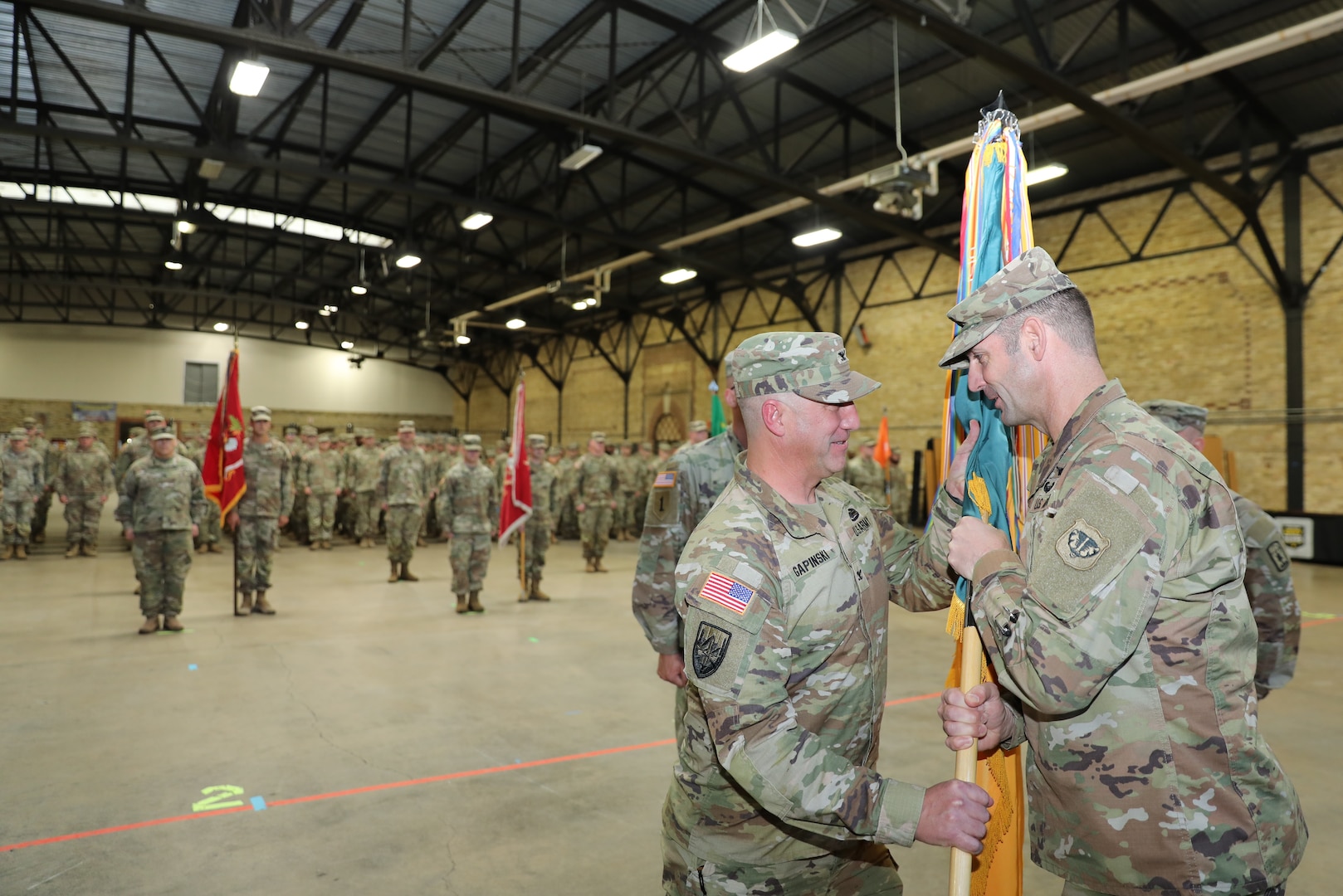 Col. Paul Gapinski receives the colors of the 157th Maneuver Enhancement Brigade from Brig. Gen. Matthew Strub, Wisconsin’s deputy adjutant general for Army, during a formal change of command ceremony Nov. 4 at the Richards Street Armory, Milwaukee. The passing of the colors is symbolic of the responsibility of the unit passing from one commander to the next. Gapinski follows Col. Eric Leckel, who most recently led the brigade headquarters on a deployment to the Horn of Africa. Wisconsin National Guard photo by Sgt. 1st Class Katie Theusch