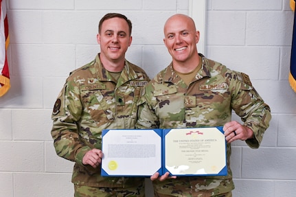 U.S. Air Force Master Sgt. Christopher Vine, a radar, airfield, and weather systems technician with the 245th Air Traffic Control Squadron at McEntire Joint National Guard Base, South Carolina Air National Guard, is presented the Bronze Star Medal from Lt. Col. Zachary Counts, the 245th ATCS commander, Oct. 15, 2023. Vine received the award for his achievements while deployed to Iraq in 2022.