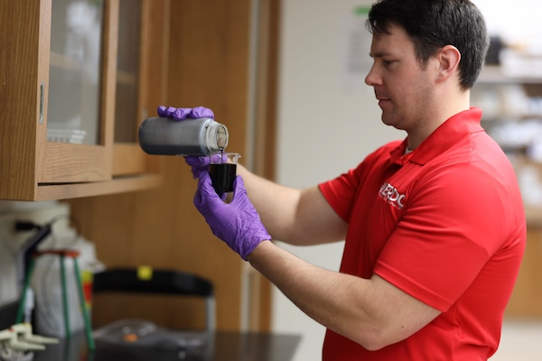 Luke Gurtowski, a research chemical engineer with ERDC’s Environmental Engineering Branch (EL), pours graphene while researching the benefits of the nanomaterial.