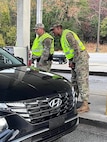 Leaders from U.S. Army Cyber Command greet drivers to Fort Eisenhower on Nov. 18, 2023 as part of the Leaders at the Gate initiative to educate the Fort Eisenhower family on the dangers of driving impaired.