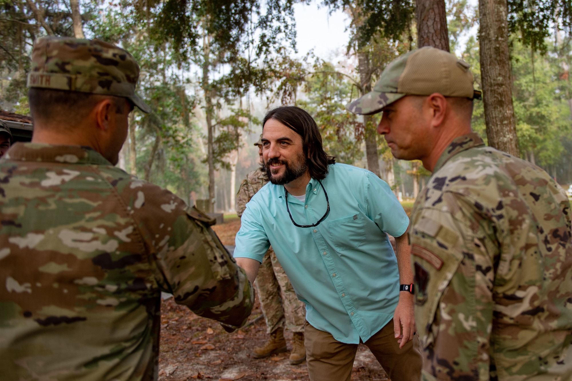Josh Davis, Grassy Pond supervisory recreation specialist, middle, shakes hands with leadership from Moody Air Force Base during a visit at Grassy Pond in Lake Park, Georgia, Oct. 30, 2023. Moody leadership toured the grounds at Grassy Pond to gain insight to the restoration process after the damage caused by Hurricane Idalia in August. (U.S. Air Force photo by Senior Airman Courtney Sebastianelli)