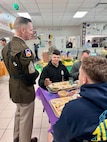 Command Sergeant Major Michael Starrett speaks to Advanced Individual Training Soldiers as they eat a Thanksgiving meal at a Warrior Restaurant on Post.