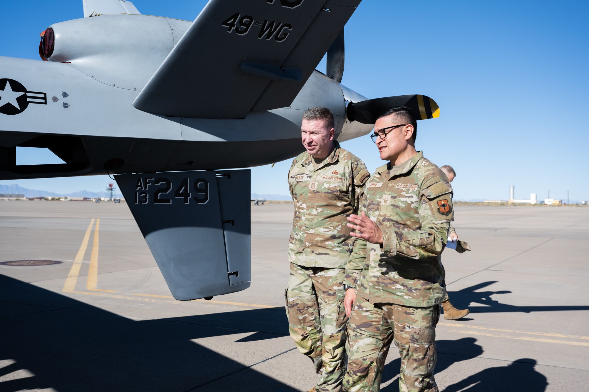 U.S. Air Force Chief Master Sgt. Chad Bickley, command chief of Air Education and Training Command, left, and U.S. Air Force Master Sgt. Michael Pena, 49th Aircraft Maintenance Squadron MQ-9 Reaper production superintendent, discuss the maintenance requirements for an MQ-9 at Holloman Air Force Base, New Mexico, Nov. 8, 2023. The Fightin’ 49ers demonstrated their innovative approach to problem solving to the top enlisted Airman in AETC, showcasing the critical role that the 49th Wing plays in the broader scope of national defense. (U.S. Air Force photo by Senior Airman Antonio Salfran)