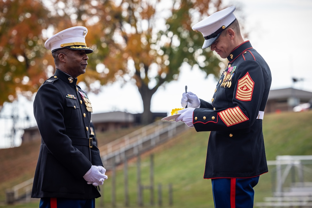 U.S. Marine Corps Col. Michael L. Brooks, base commander, Marine Corps Base Quantico, left, a native of South Boston, Virginia, presents the cake to Sgt. Maj. Carlos A. Ruiz, sergeant major of the Marine Corps, right, a native of Sonora, Mexico, during the cake cutting ceremony in honor of the 248th Marine Corps birthday at Butler Stadium on MCB Quantico, Virginia, Nov. 7, 2023. The annual cake cutting ceremony is a long-standing tradition which celebrates the establishment of the United States Marine Corps. The Marine Corps birthday is celebrated every year to commemorate the birth of the Corps and honor the service and sacrifices of all Marines, past and present. (U.S. Marine Corps photo by Lance Cpl. Joaquin Dela Torre)