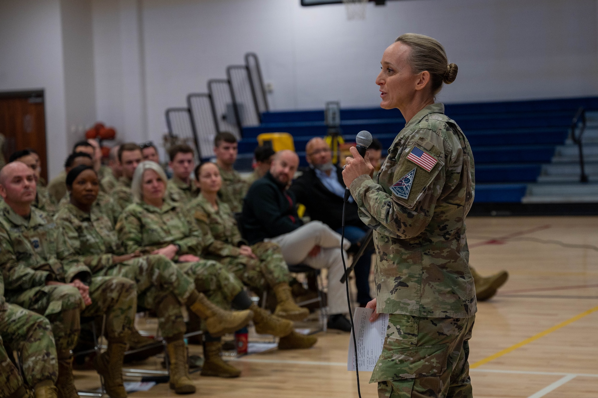 uniformed member speaks in front of other members.