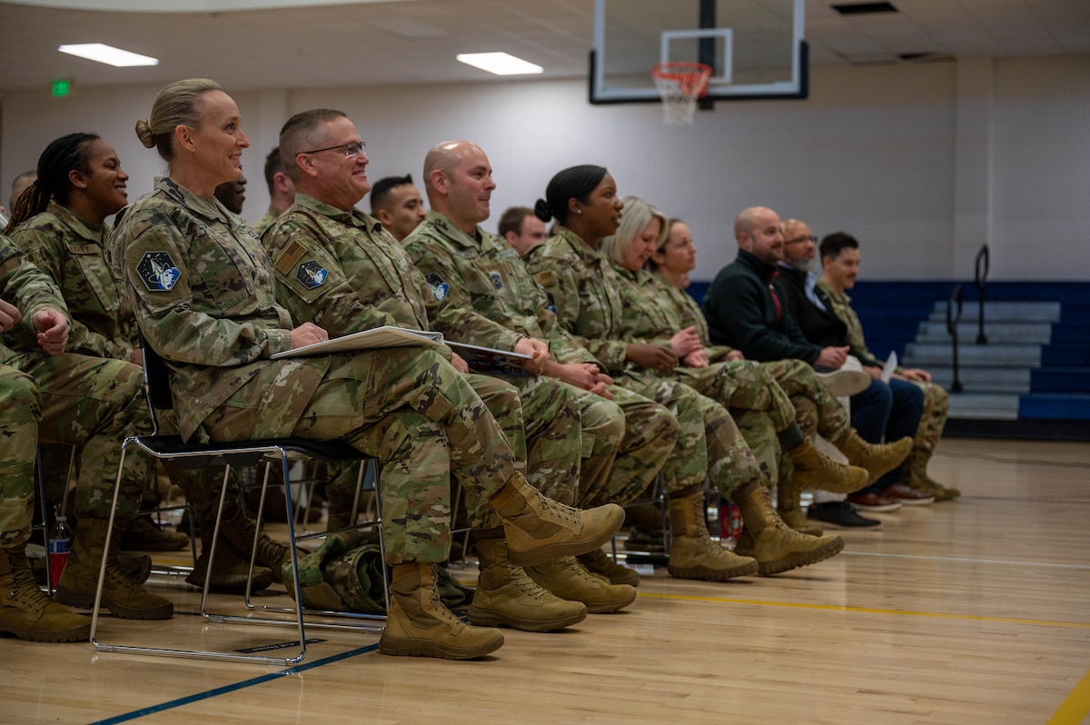 Servicemembers seated in a gymnasium.