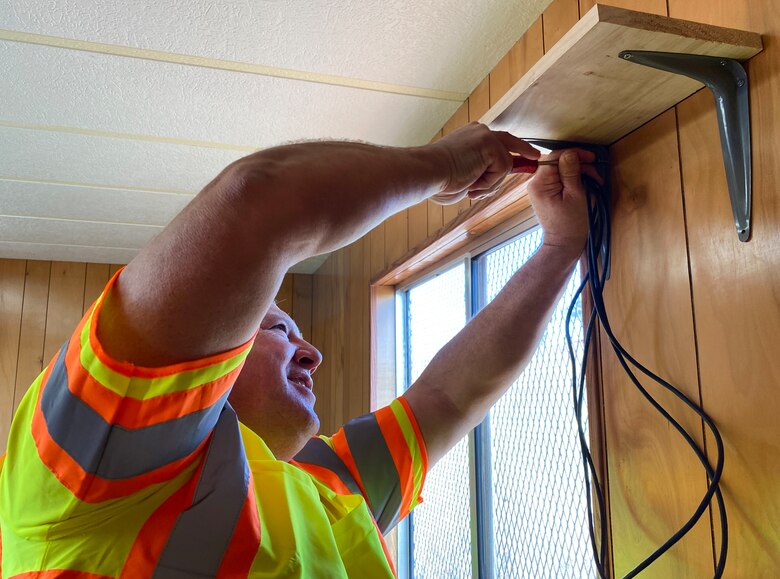 U.S. Army Corps of Engineers CIO/G6 Enterprise Emergency Response Team member Dale Carton installs a shelf for a Wi-Fi router in a construction trailer at the site where a temporary elementary school is being built.
