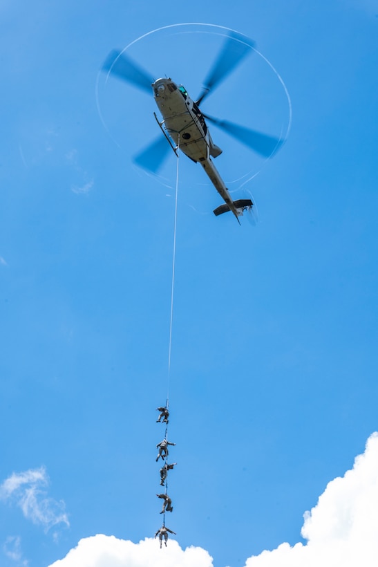 U.S. Marines with III Marine Expeditionary Force tack to a UH-1Y Venom assigned to Marine Light Attack Helicopter Squadron 169 during special patrol insertion and extraction training at Landing Zone Starling, Camp Schwab, Okinawa, Japan, Sept. 21, 2023. SPIE rigging techniques are used to rapidly insert and extract Marines when a landing zone is unavailable. (U.S. Marine Corps photo by Cpl. Tyler Andrews)