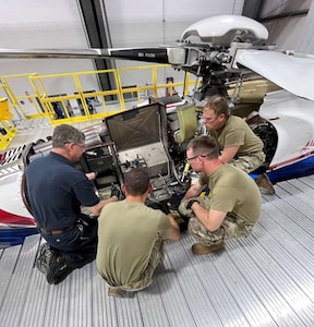 people inspect an engine