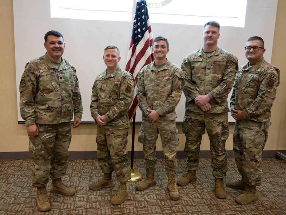 A weapons load team from the 34th and 37th aircraft maintenance units pose with their leadership following a coin ceremony at Ellsworth Air Force Base, South Dakota, Nov. 22, 2023.