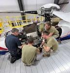 people inspect an engine