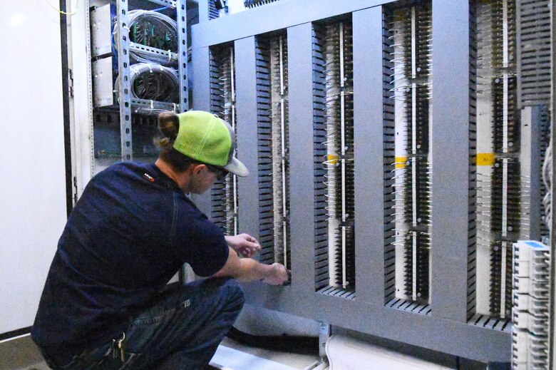 Man in hardhat examines electrical machinery at Hydro Power Plant.