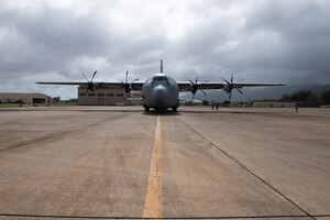 A C-130J aircraft parks at an airfield.