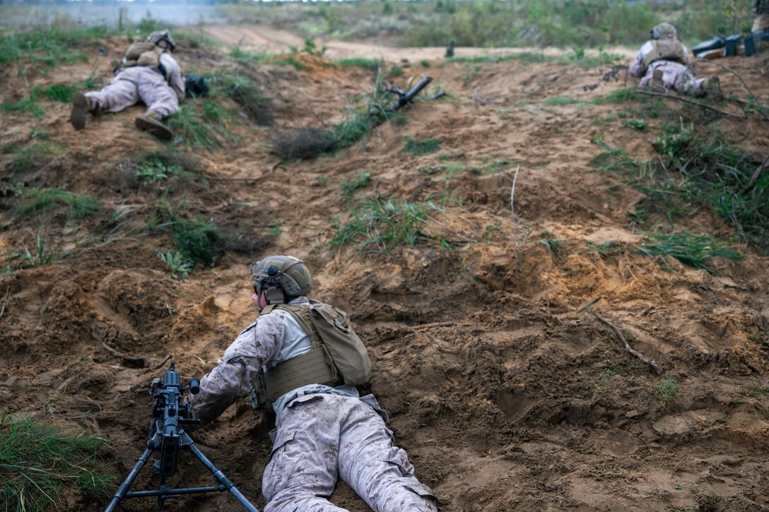 U.S. Marines with Fleet Anti-Terrorism Security Team Company, Europe (FASTEUR) crawl up a hill while carrying M240 machine guns during a live-fire shoot at a firing range in Lielvārde Airfield, Latvia, Oct. 5, 2023. Task Force 61/2.3 (FASTEUR), under the tactical command and control of Task Force 61/2, provides capabilities such as rapid response expeditionary anti-terrorism and security operations in support of Commanders, United States European Command (COMESEUCOM) and as directed by Commander, U.S. 6th Fleet (C6F) in order to protect vital naval and national assets. (U.S. Marine Corps photo by Lance Cpl. Jack Labrador)