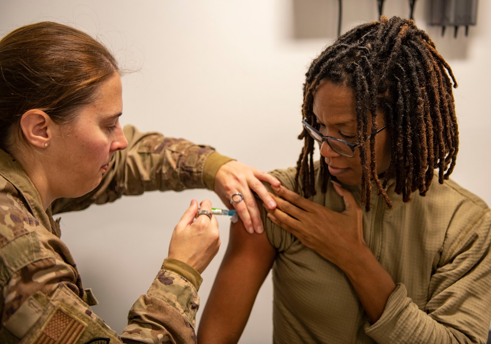 Maj. Heather Quigg, 423d Medical Squadron healthcare integrator, left, gives Senior Master Sgt. Yarden Smash-Robinson, Joint Intelligence Command U.S. Africa Command operations superintendent, a flu vaccine at RAF Alconbury