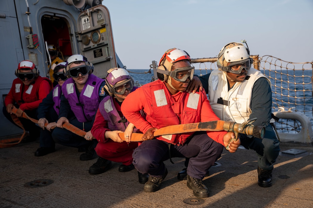 U.S. Navy Sailors assigned to the crash and salvage team man a hose during an aircraft firefighting drill aboard the guided-missile destroyer USS Gravely (DDG 107) in the Arabian Gulf Nov. 22, 2023.