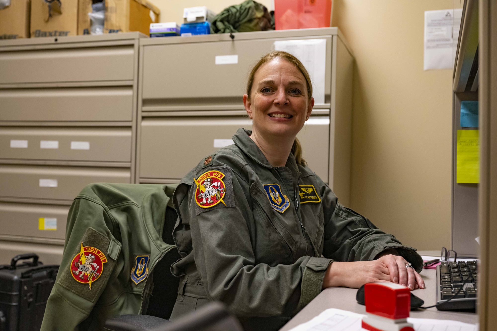 Maj. (Dr.) Jennifer Waterman, 303rd Fighter Squadron Flight Doctor charts at her desk at Whiteman AFB, MO on November 3, 2023. Like many traditional reservists, Waterman has two careers. In her civilian role, she is an orthopedic surgeon newly relocated from Kansas to Maine.
