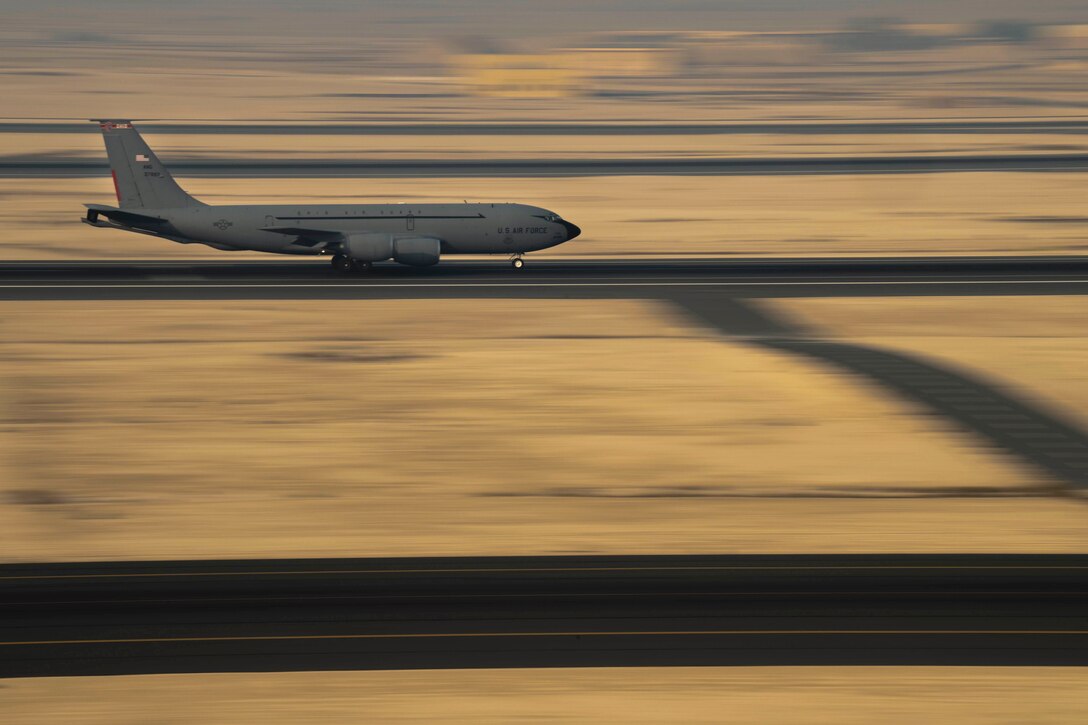 An aircraft takes off from a runway with blurred surroundings.