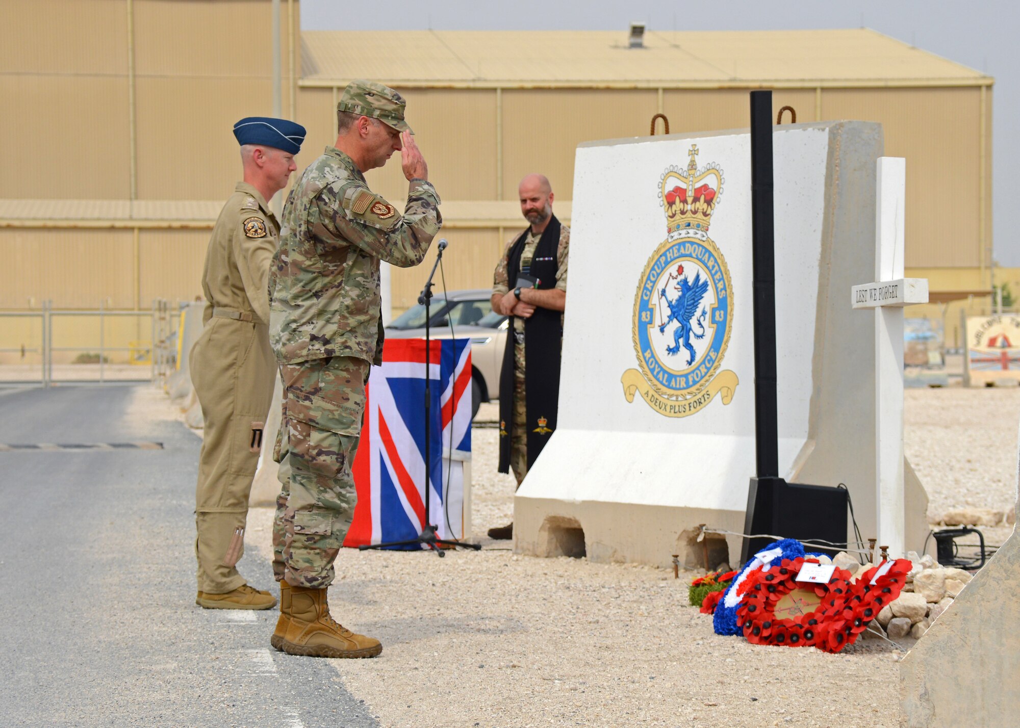 Brig. Gen. David Mineau, Ninth Air Force Deputy commander, salutes poppy wreaths at a Remembrance Day ceremony.