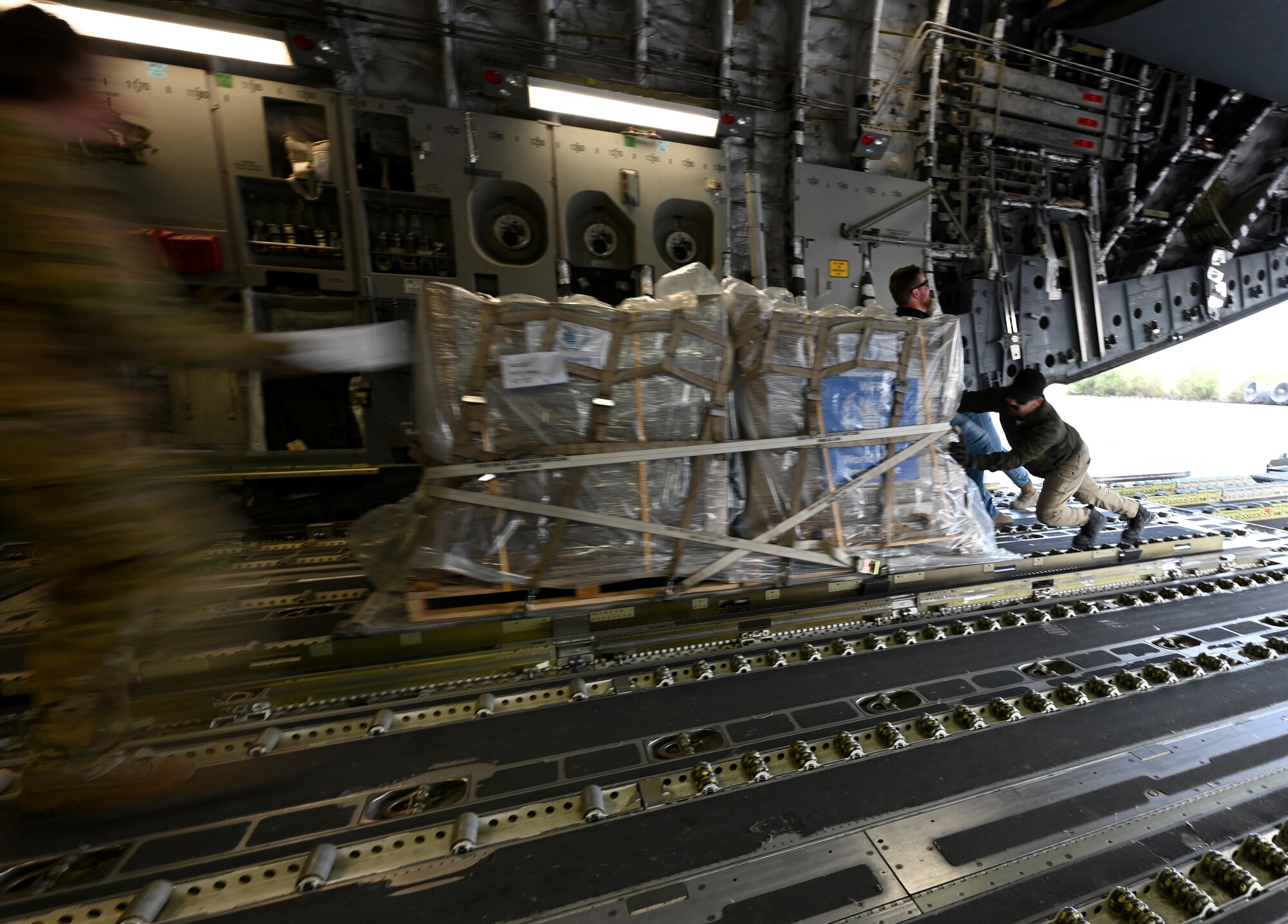 Airmen and U.S. Agency for International Development personnel offload more than 54,000 pounds of humanitarian aid from a C-17.