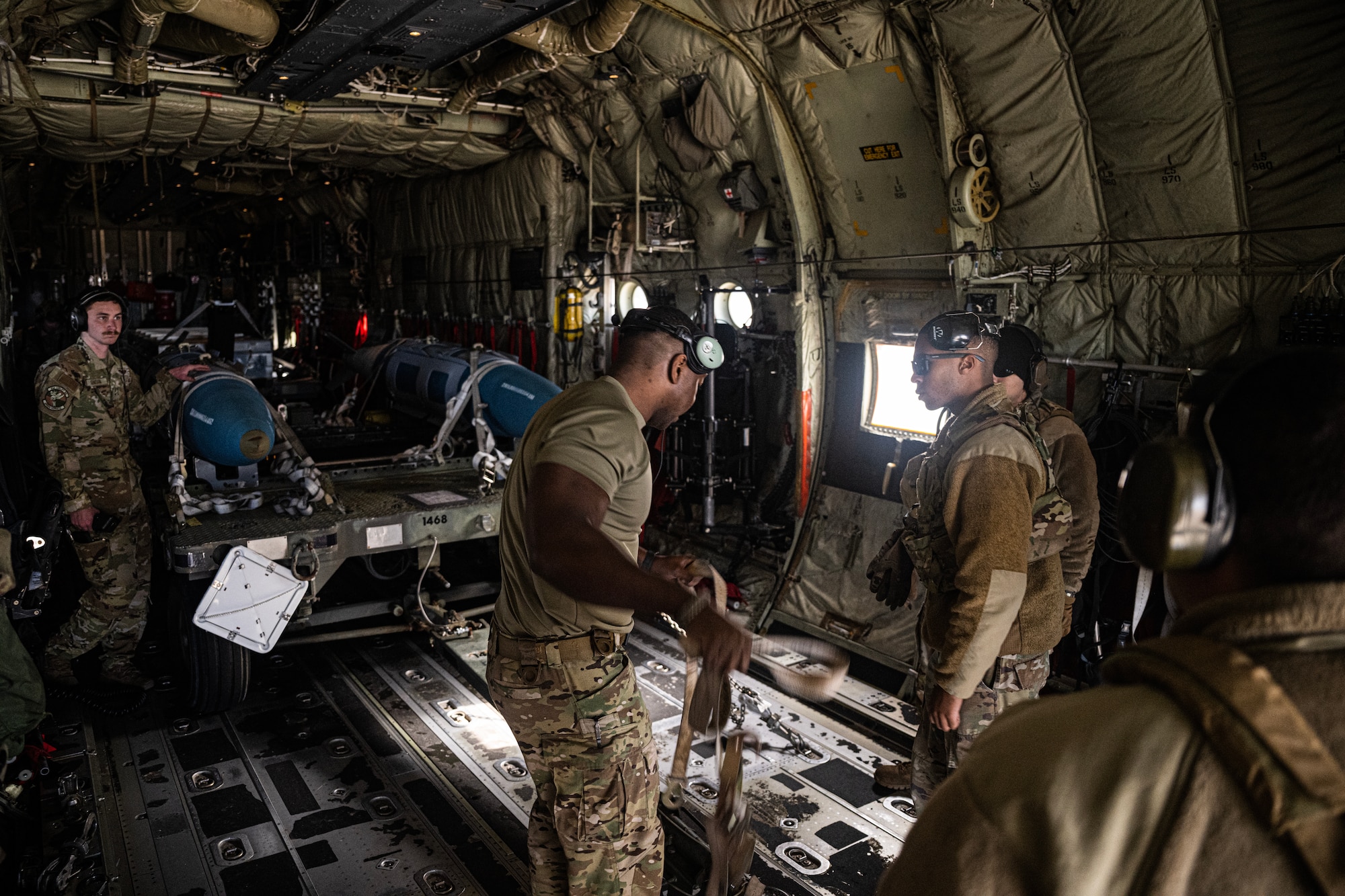 Airmen load fake bombs in the back of a C-130J