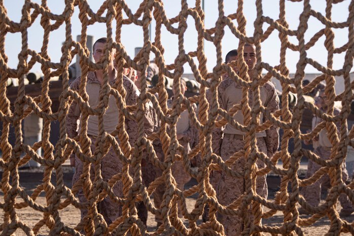 U.S. Marine Corps recruits with Bravo Company, 1st Recruit Training Battalion, prepare to execute a cargo net obstacle during the Confidence Course at Marine Corps Recruit Depot San Diego, Nov. 20, 2023. The Confidence Course challenges recruits physically and mentally through obstacles that require confidence in their strength, balance, and determination. (U.S. Marine Corps photo by Cpl. Elliott A. Flood-Johnson)