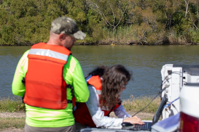 Rebecca Capps, U.S. Army Corps of Engineers (USACE), Galveston District (SWG), Advanced Data Section physical scientist and drone operator, right, monitors data collected from the Z-boat, a remote-controlled hydrographic survey vessel, as Roger Stillick, Advanced Data Section drone operator, drives the Z-boat during a survey of a section of the Trinity River, Nov. 15, 2023.