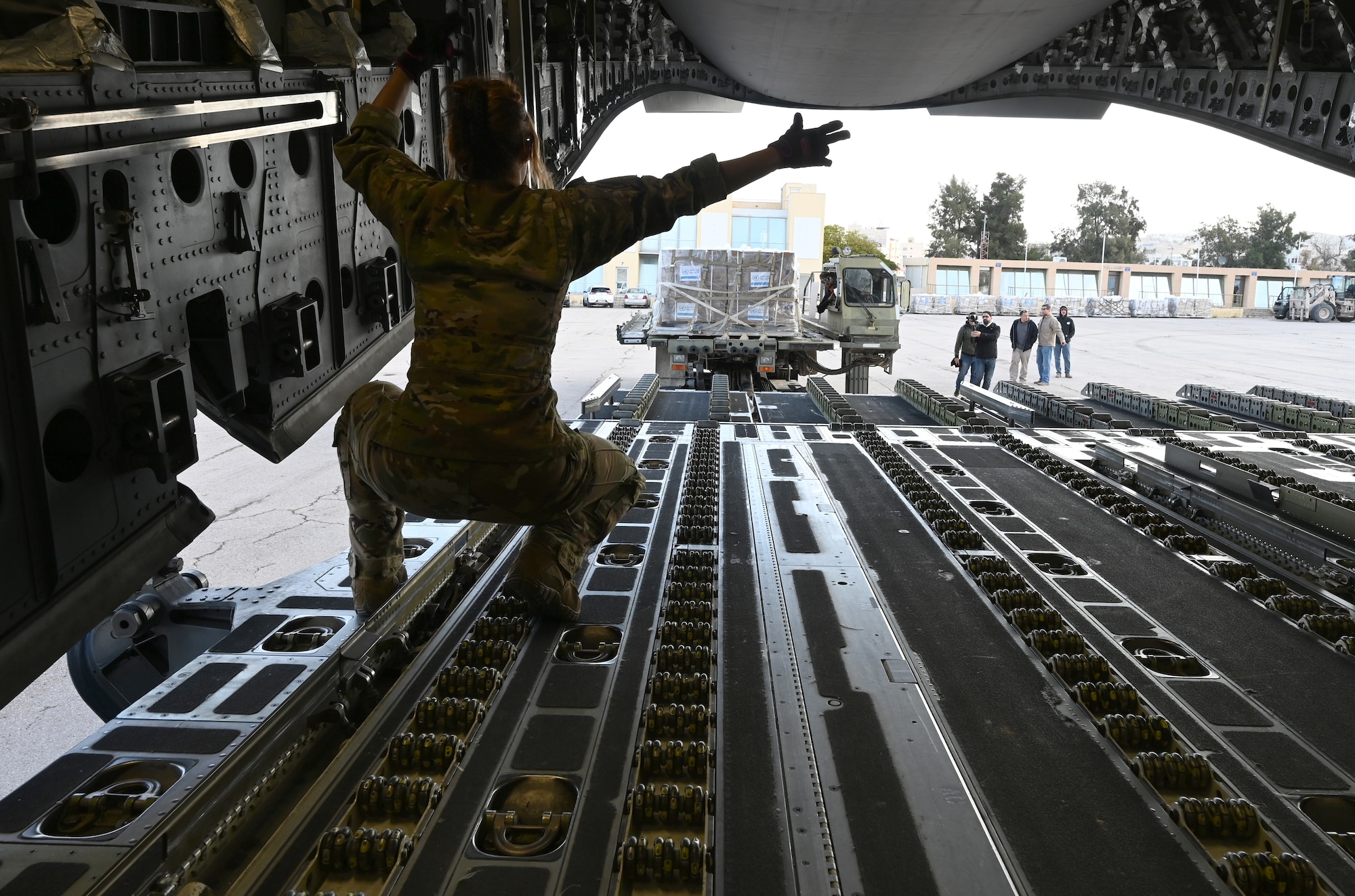 Staff Sgt. Jeanne Caron ushers in 24.7 metric tons of humanitarian aid destined for Gaza aboard a C-17.