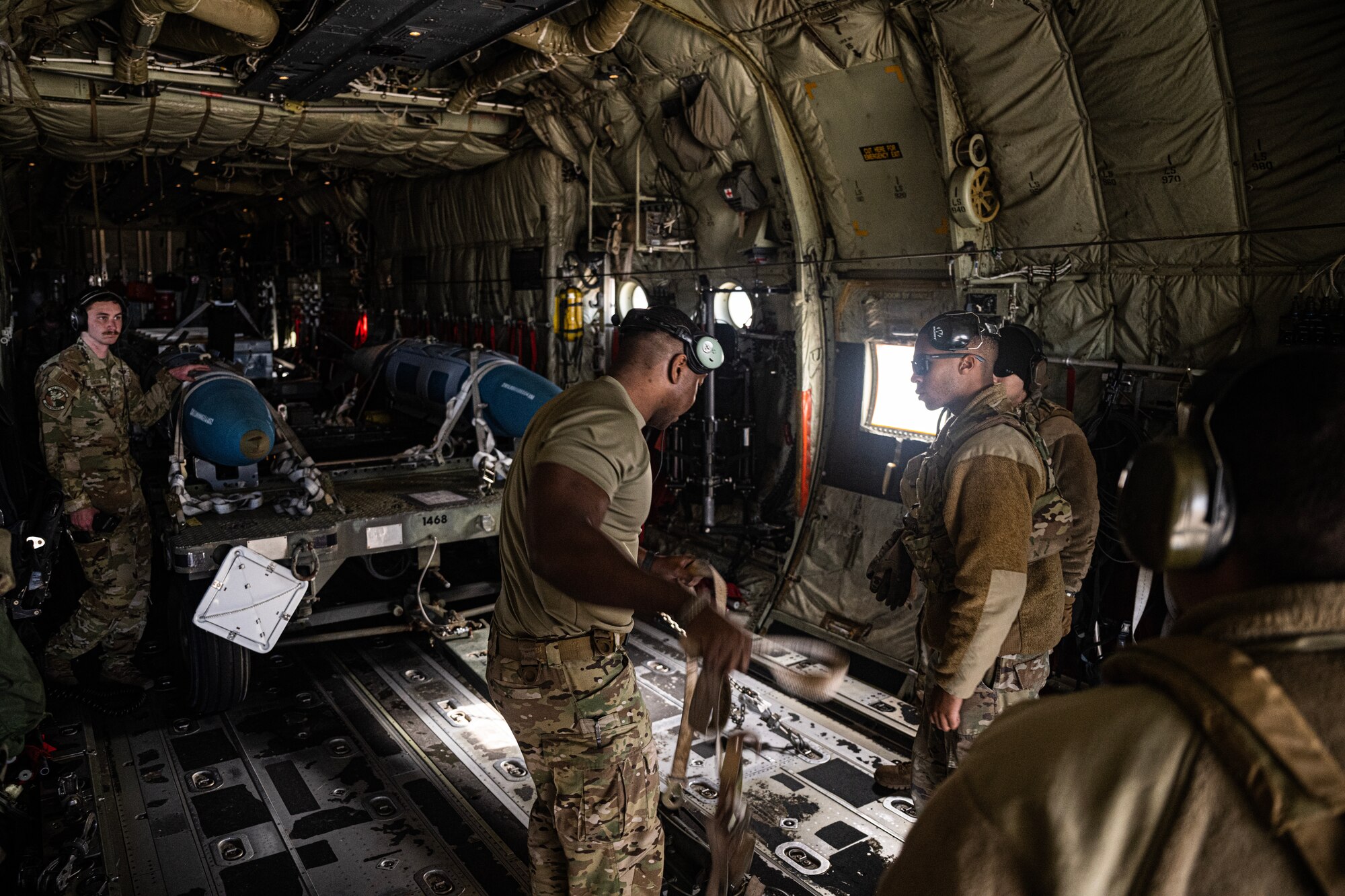 Airmen load fake bombs in the back of a C-130J